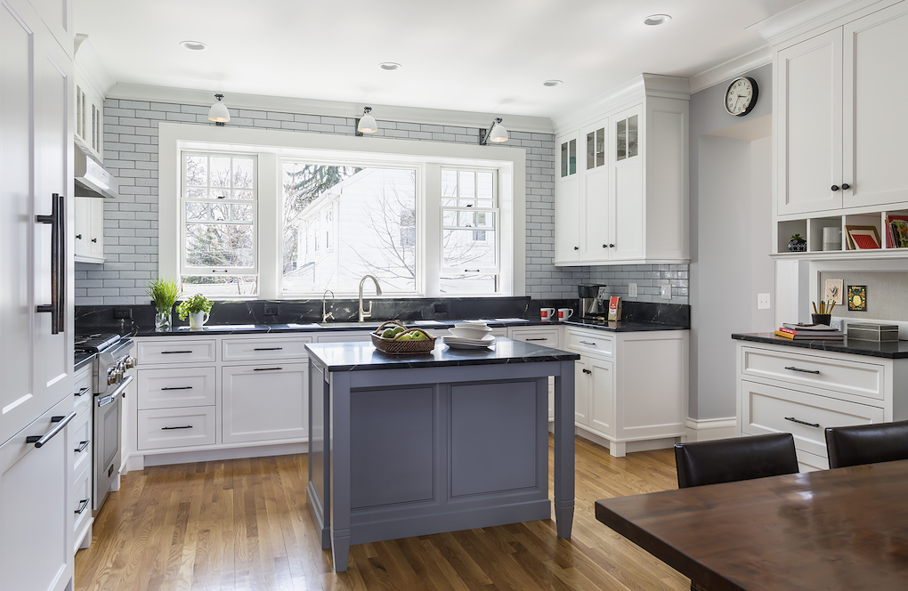 White kitchen with large window and small gray island