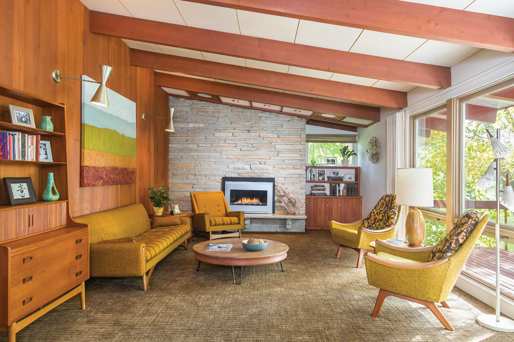 Living room of mid-century house with cherry paneling and vaulted ceilings and exposed beams.