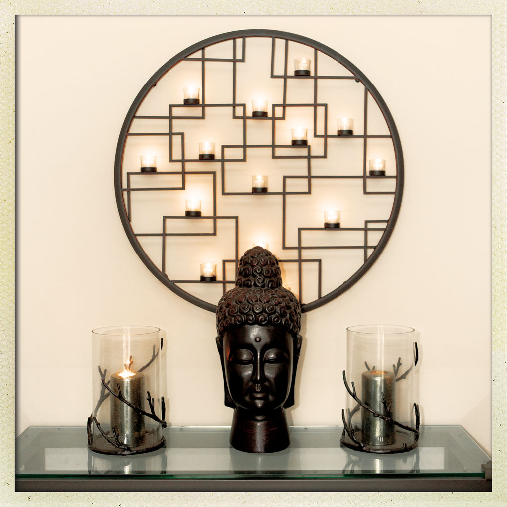 A tea-light candle sconce and Buddha head welcome guests at Jane and Daniel Greens' entryway.