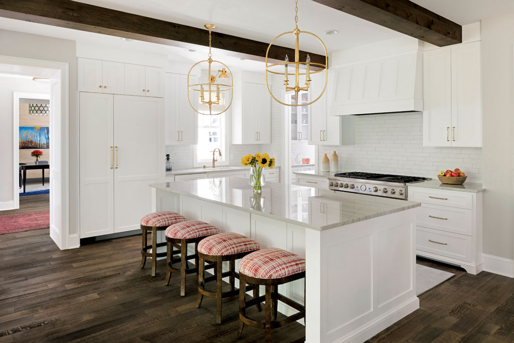 The kitchen boasts a quartzite island with seating for four and white cabinetry.
