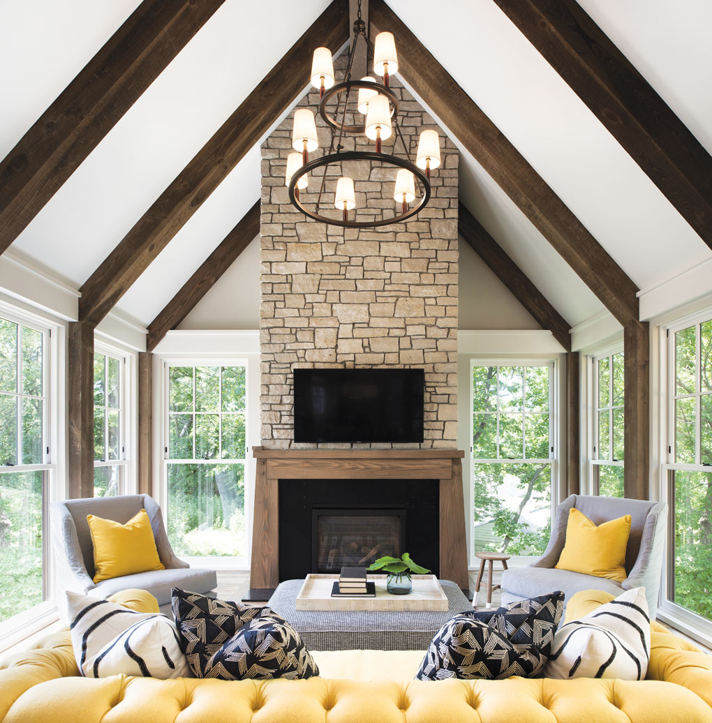 A year-round porch, dubbed the “Minnesota Room,” creates an outdoorsy vibe with its timbered beams, stone fireplace, and double-hung windows on three sides.