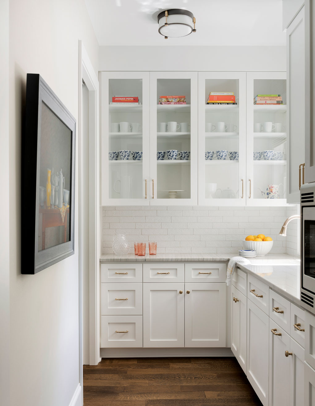 The adjacent pantry/galley keeps prep messes out of sight and features white cabinetry.