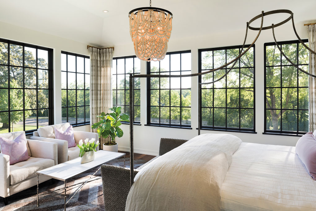 In the master bedroom, black-framed windows showcase 270-degree views of the trees and river.