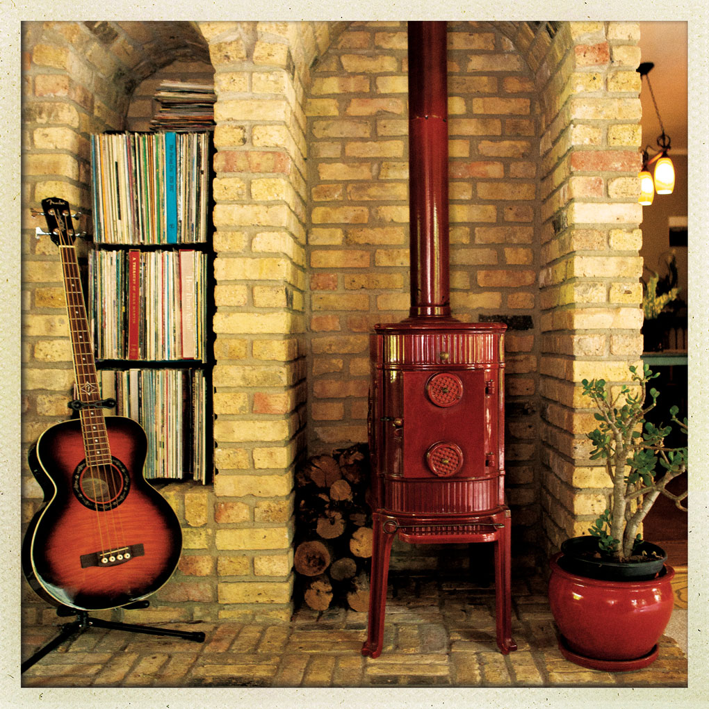 A vinyl collection in nooks near a red lacquer wood-burning stove surrounded by Chicago brick.
