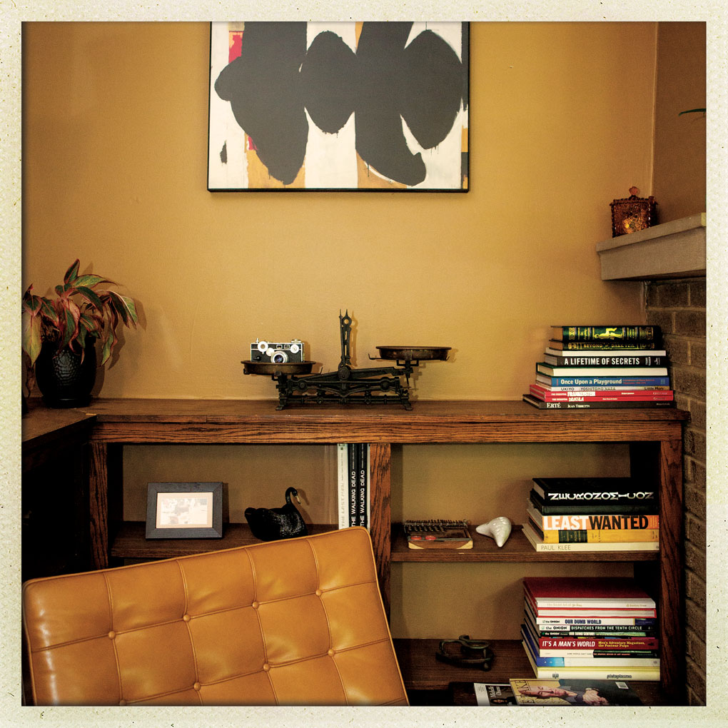 An antique scale sits on a shelf behind a Barcelona chair.