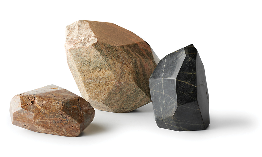 Three rock sculptures, one brown, one beige and one charcoal.