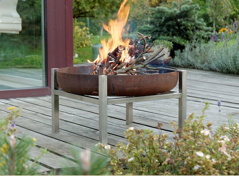 A fire pit with legs on a porch.