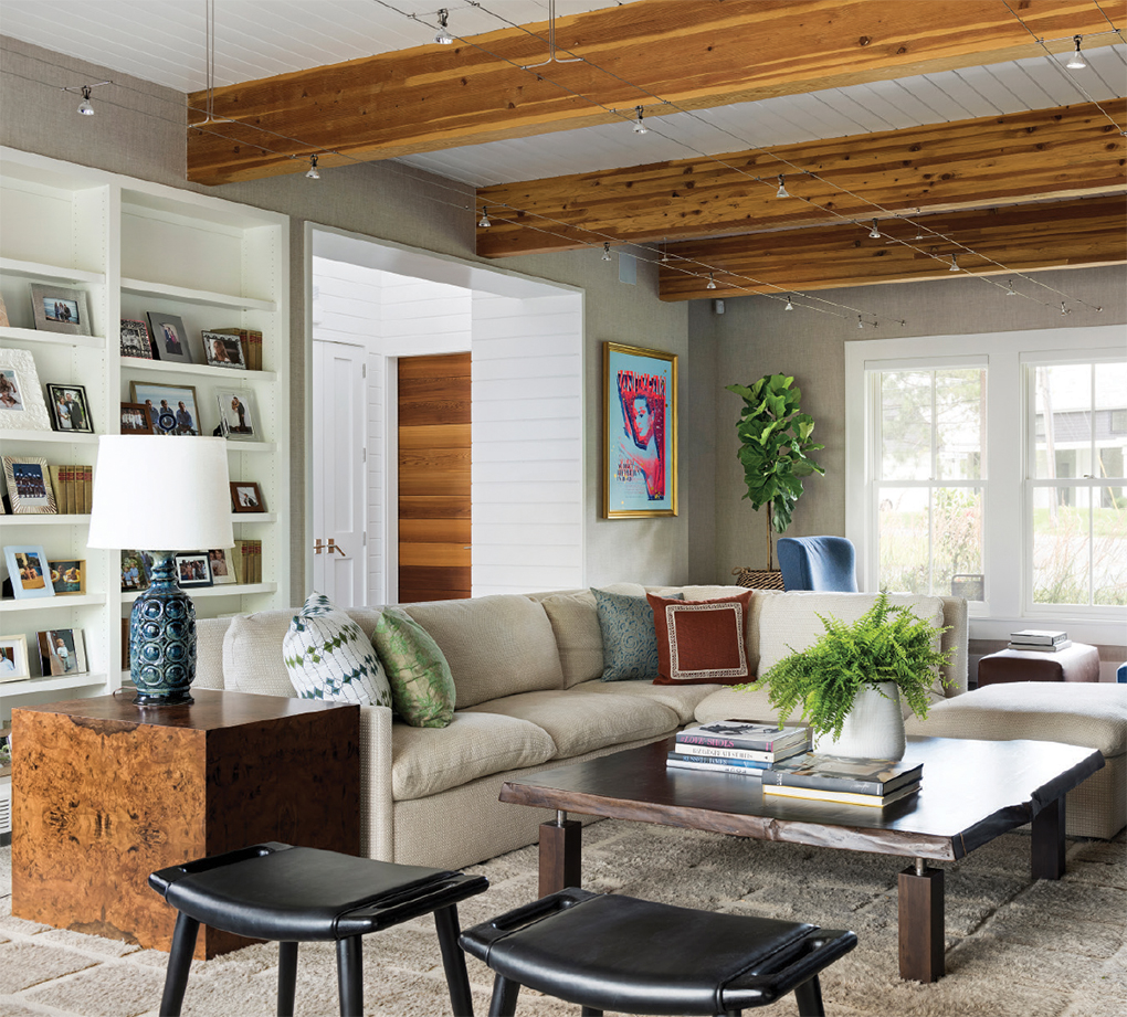 A large family room with seating, a table and exposed wooden beams.