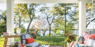 Porch overlooking Lake Minnetonka with a porch swing and chair and drink cart.