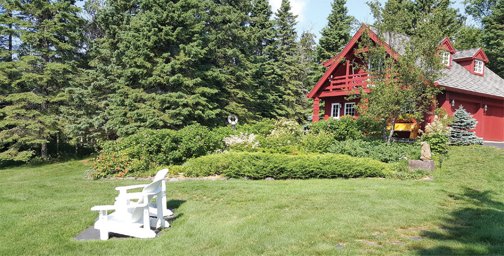 A red timber-frame Lundie cabin with a large yard.