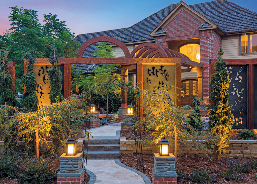 Aluminum, laser-cut panels form the sliding gate beneath the arched front entrance.