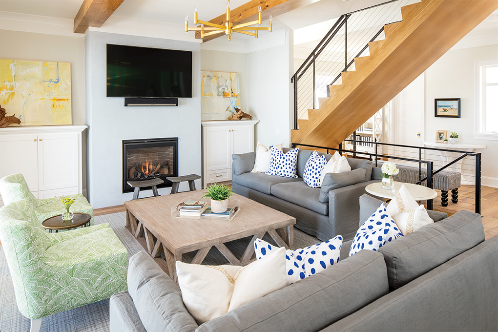 The family room features loads of comfy seating. A suspended white oak staircase, and black metal and cable railings add modern flair to the space.