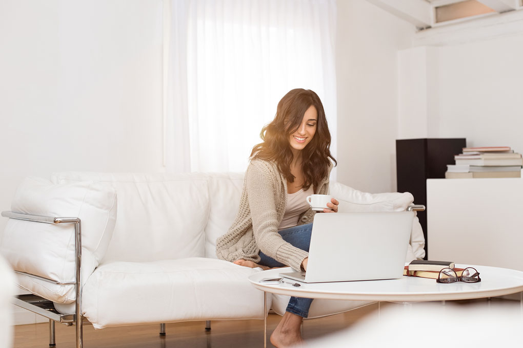 A woman sitting on her couch using her laptop for online shopping at Solid Manufacturing Co. and more.