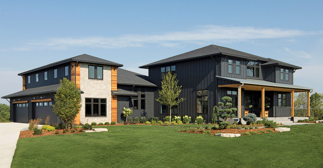 Designed by Divine Custom Homes, this new home’s contemporary, mountain-lodge style is heightened by black board-and-batten siding and stone, cedar, and iron accents.