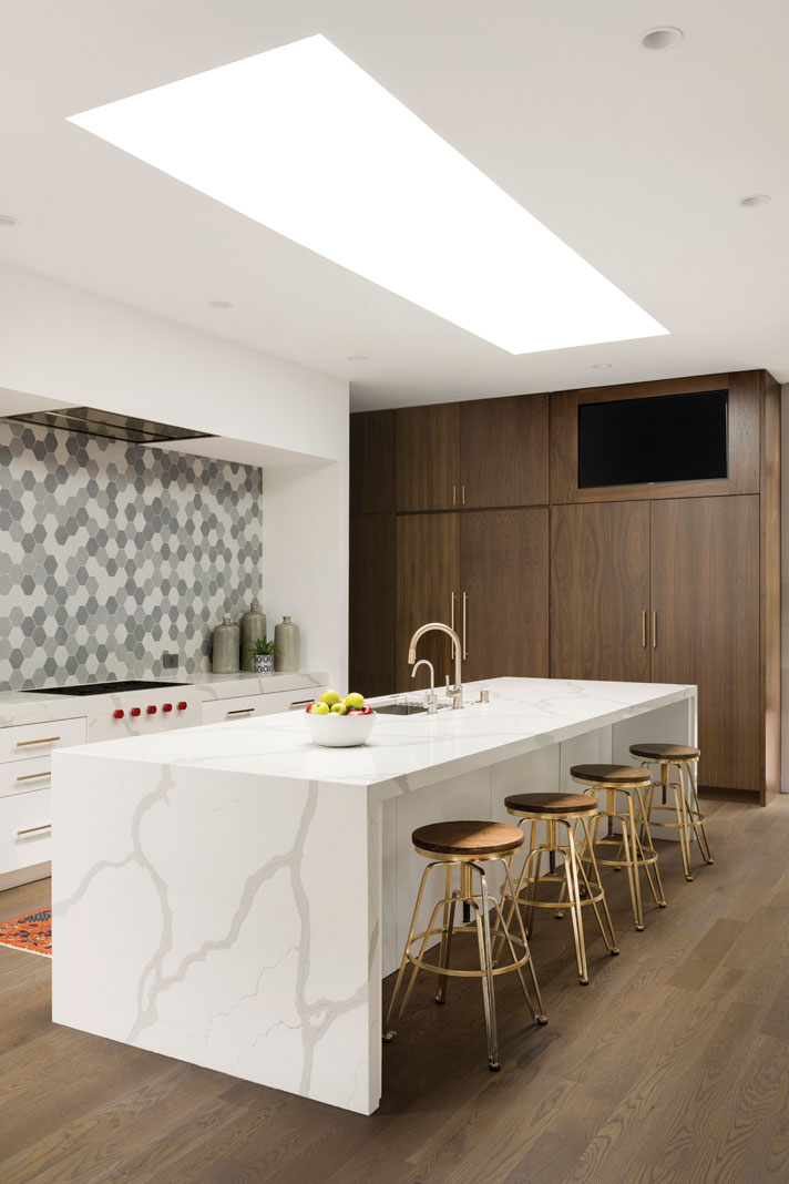 A kitchen, an entertainer’s dream, offers a gorgeous backsplash with plentiful prep space courtesy of spacious quartz countertops. Part of Midwest Home's 2018 Luxury Home Tour.