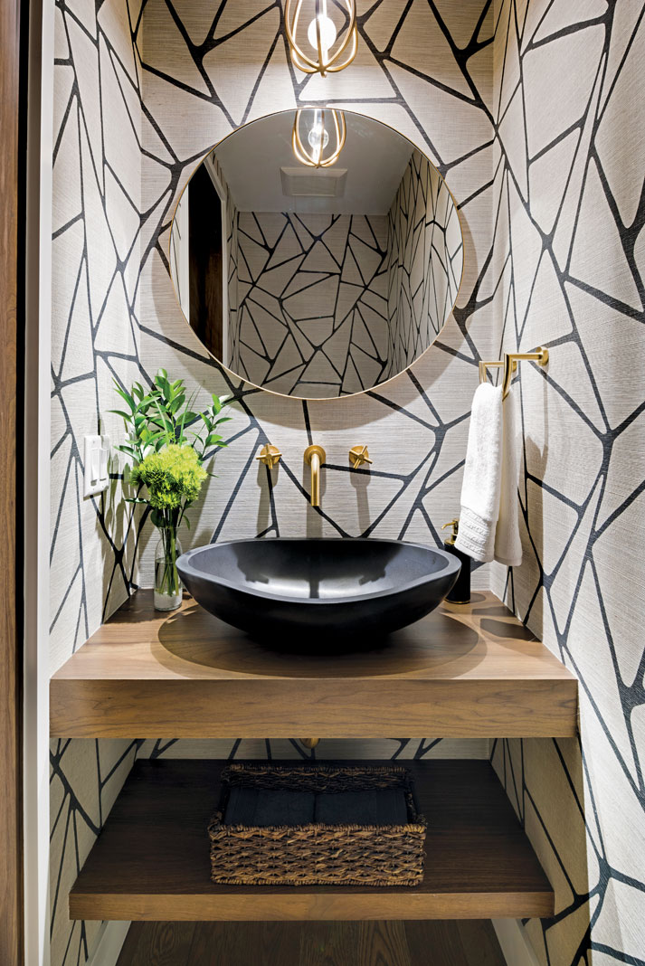 Geometric patterns on the wall and a black stone basin sink create unique textures in a powder room. Part of Midwest Home's 2018 Luxury Home Tour.