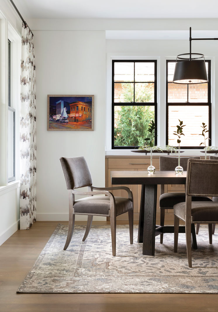 The plentiful windows in the formal dining room and glass-walled family lounge ensure daylight and outdoor views while contemporary art and brightly patterned textiles add pops of color throughout the spaces. Part of Midwest Home's 2018 Luxury Home Tour.