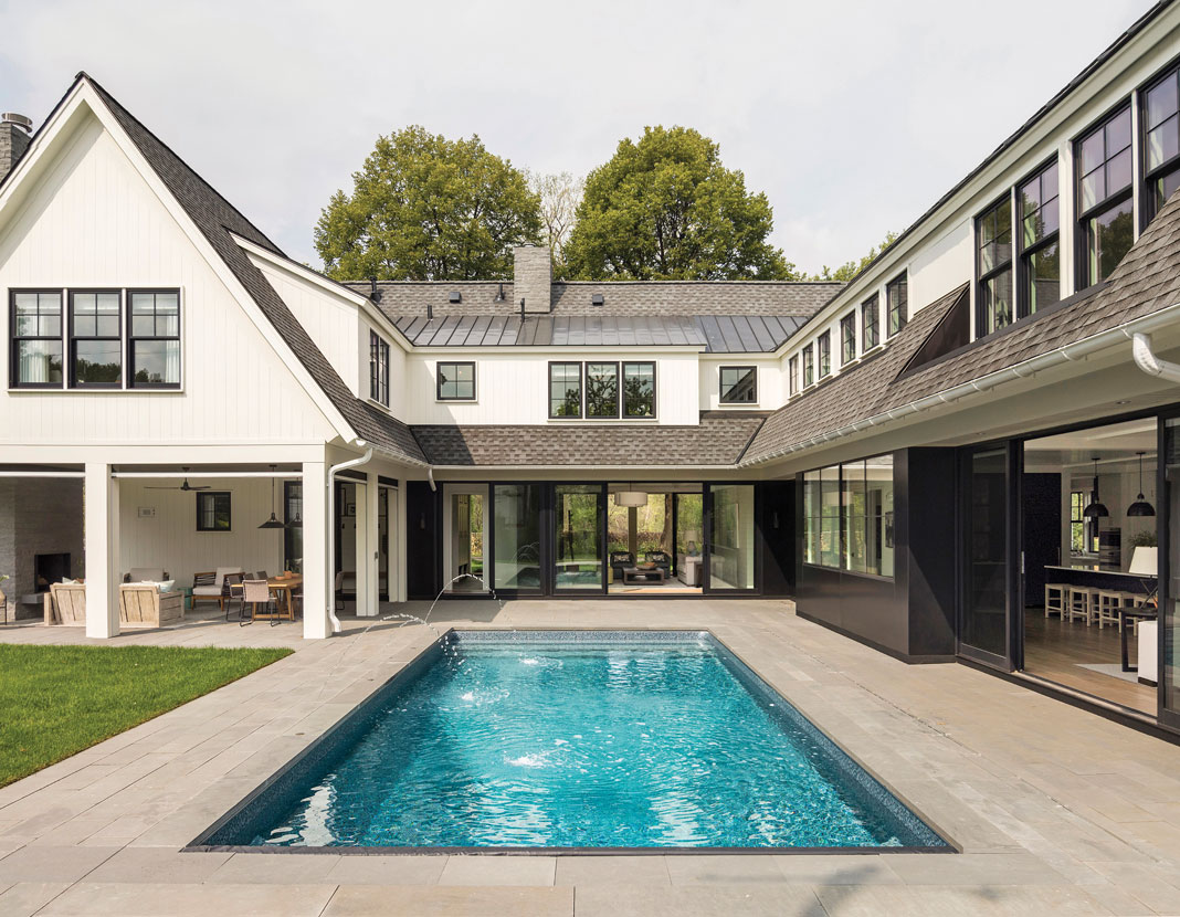 Perhaps the most memorable elements of the home are its U-shape–the house wraps around the swimming pool and patio in the backyard–and its steep rooflines and classic white exterior, which create a modern-yet-traditional cottage motif. Part of Midwest Home's 2018 Luxury Home Tour.