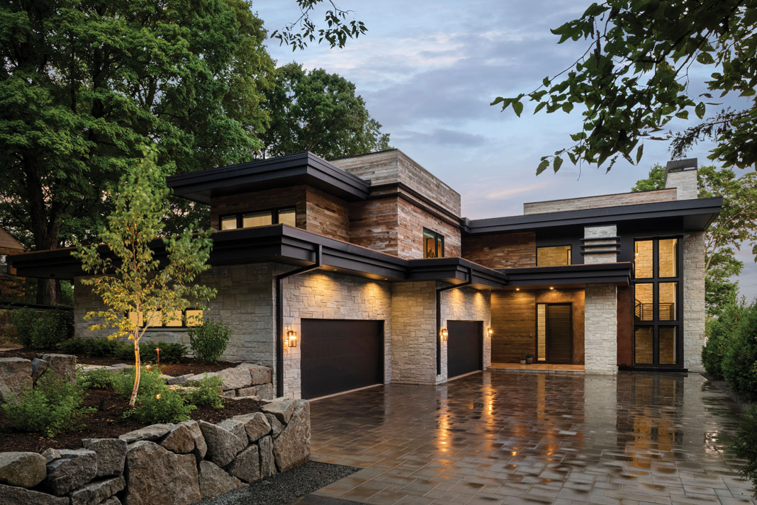 Built by Stonewood, LLC, this Orono home’s "mountain-modern" exterior combines a contemporary aesthetic with rustic materials, such as reclaimed barn-wood siding paired with dark metal accents. Featured on Midwest Home's 2018 Luxury Home Tour. 