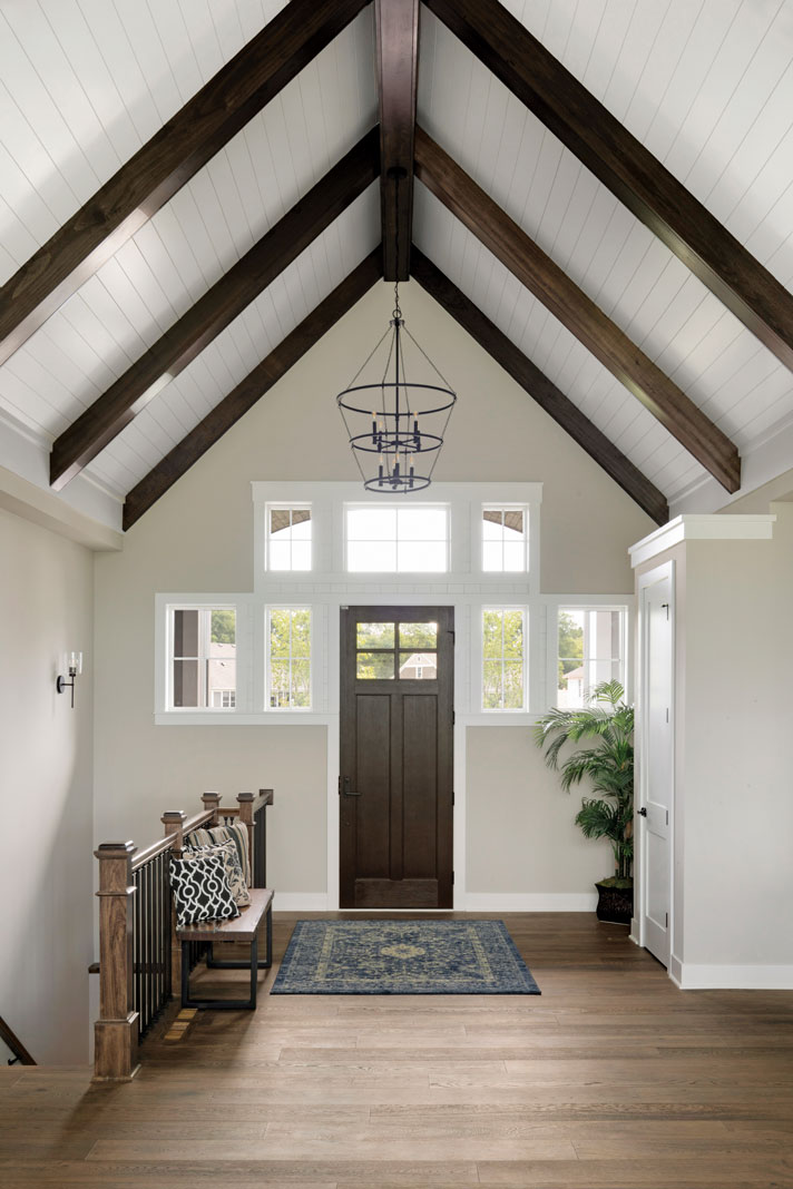 A lofty cathedral ceiling featuring dark wood beams and white shiplap lend a sense of contemporary grandeur to this traditional cottage-inspired Lake Elmo home. Part of Midwest Home's 2018 Luxury Home Tour.