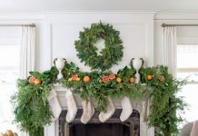 Fresh evergreens, citrus, and faux fur stockings decorate the period fireplace, capturing the spirit of the season and the expert blend of old and new in the stately 1920s Georgian.