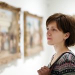 Woman looking at paintings/photos in a museum