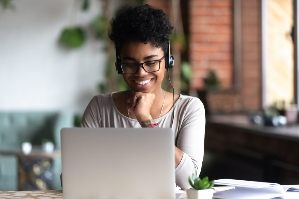 Women sits with laptop computer with headphones