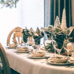 A dining table with a green and white holiday tablescape.